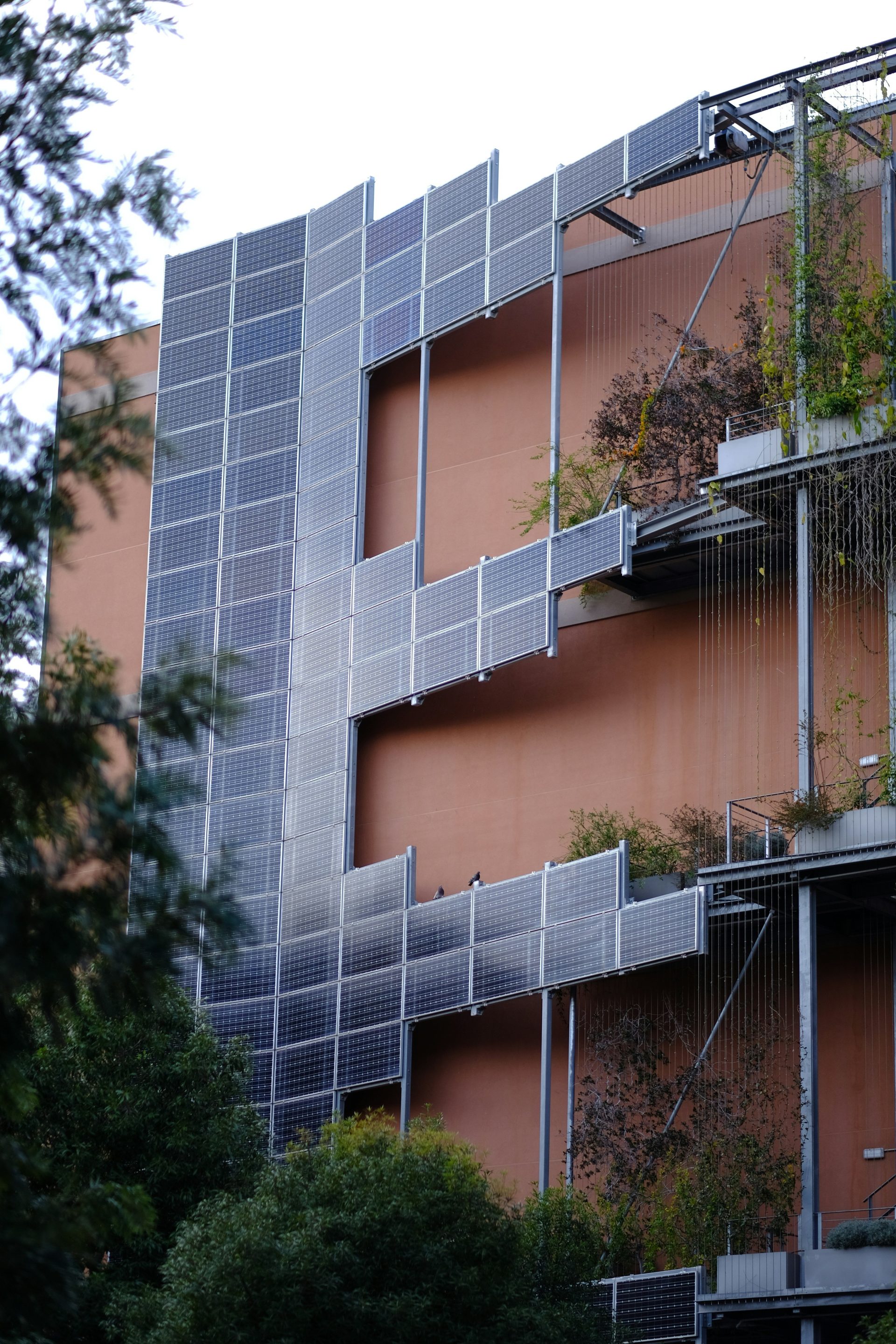 Moderne Gebäudefassade mit Solarpaneelen und Begrünung